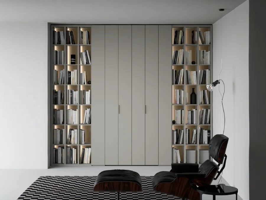 Libreria a giorno lineare e geometrica, in laccato opaco, arricchita dalla schiena in laccato metallico Oxid e impreziosita dall’illuminazione a led passaggio porta di Caccaro