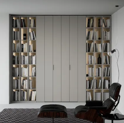 Libreria a giorno lineare e geometrica, in laccato opaco, arricchita dalla schiena in laccato metallico Oxid e impreziosita dall’illuminazione a led passaggio porta di Caccaro